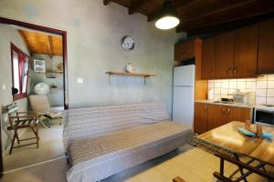 a small bedroom with a bed and a kitchen at Limnos Stone House in Kalliópi