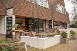 een restaurant met tafels en stoelen ervoor bij Fletcher Hotel-Restaurant Wolfheze in Wolfheze