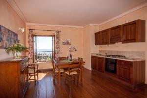 uma cozinha com armários de madeira e uma mesa com cadeiras em Residenza Palazzo Saloni em Montalcino