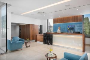 a living room with blue chairs and a large window at Hotel Milan in Pula