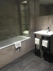a bathroom with a sink, mirror and bath tub at Grey Street Hotel in Newcastle upon Tyne