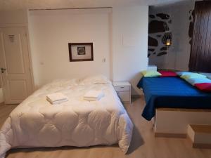 Casa Bento Teixeira في بلمونت: غرفة نوم بسرير ابيض كبير ومفرش ازرق