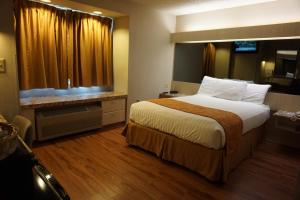 a hotel room with a large bed and a window at CenterWay Hotel Buffalo North Near University in Tonawanda +29 photos