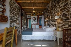 1 dormitorio con 1 cama en una pared de piedra en Milos Dream Life, en Triovasálos