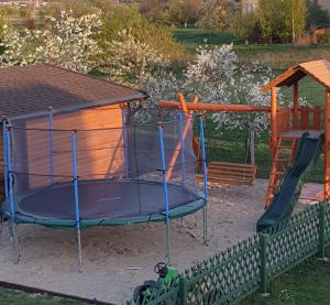 a playground with a trampoline and a house at Žuvėdrų g. 27 in Šventoji