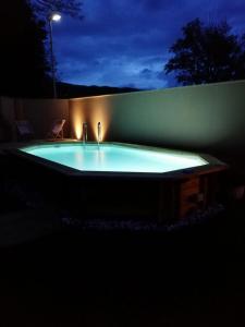 a hot tub with two faucets in a backyard at night at B&B da Morena in Gorfigliano