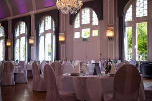 a room with white tables and chairs and windows at Hotel Tenbrock - Restaurant 1905 in Gescher