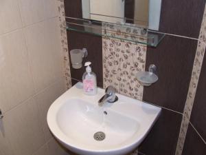 a bathroom sink with a soap bottle on it at Asparuhov Guest Rooms and Apartments in Varna City