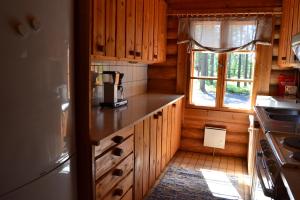 a kitchen with wooden cabinets and a counter top at Forest Cottage in Säkylä