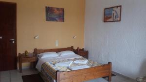 a bedroom with a wooden bed in a room at Antikristo Rooms in Karteros