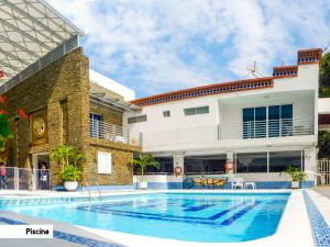 Villa con piscina frente a un edificio en Hotel Tayrona Rodadero, en Santa Marta