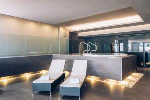 a kitchen with two white chairs and a tub at Iberostar Selection Lagos Algarve in Lagos