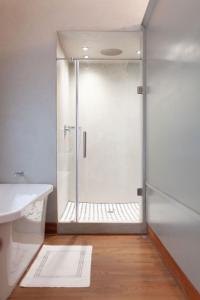 a shower with a glass door in a bathroom at Bella Blue Guesthouse in Bloemfontein