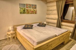 a bedroom with a wooden bed with two pillows at Zruby Pod Chopkom in Tale