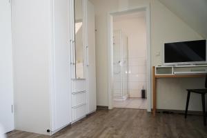 een woonkamer met een televisie en een bureau met een televisie bij Ostseehotel Hunhoi in Niesgrau