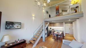 a living room and kitchen with a staircase in a loft at Porto Enetiko Suites in Rethymno Town
