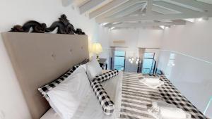 a bedroom with a bed with a black and white pillow at Porto Enetiko Suites in Rethymno