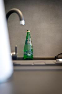 a green soda bottle sitting on a kitchen sink at Apartament Kalinka in Nysa