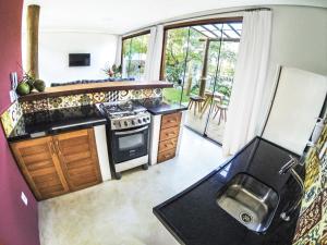 uma cozinha com um fogão, um lavatório e um frigorífico em Vila Pérola Negra em Itacaré