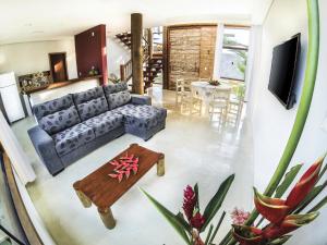 Vila Pérola Negra في إيتاكاري: غرفة معيشة مع أريكة وطاولة
