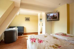 um quarto com duas camas e uma televisão na parede em Hotel Mosella em Bullay