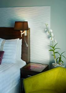 Holiday Inn Santo Domingo, an IHG Hotel في سانتو دومينغو: غرفة نوم بسرير وطاولة مع مصباح