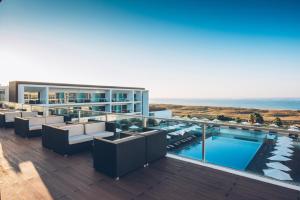 a resort with a swimming pool and the ocean at Iberostar Selection Lagos Algarve in Lagos