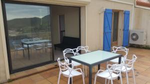 a patio with a table and chairs on a balcony at cerbere terrimbo in Cerbère