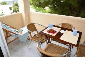 a table and chairs with a plate of fruit on a balcony at Aelia Houses in Agia Marina Aegina