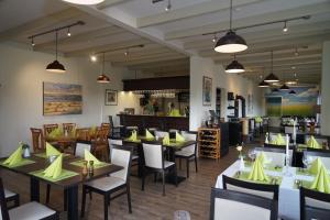 a restaurant with tables and chairs with yellow napkins at Ostseehotel Hunhoi in Niesgrau