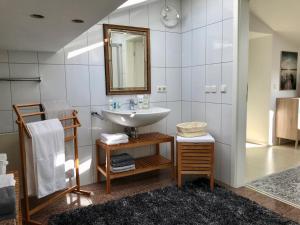 ein Bad mit einem Waschbecken und einem Spiegel in der Unterkunft Haus DreiSeenBlick in Rimsting
