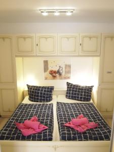 ブラウンラーゲにあるApartment Schimmerのベッドルーム1室(ピンクの枕が付くベッド2台付)