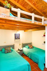 two beds sitting next to each other in a room at La Casa de Piedra in Guatapé