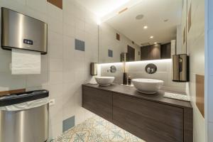 La salle de bains est pourvue de 2 lavabos et d'un grand miroir. dans l'établissement Hotel Cajou, à La Panne