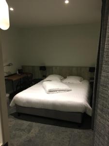 a bedroom with a bed and a lamp at Hotel Restaurant au Floridor in Thann