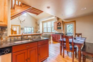 a kitchen with a sink and a wooden table at Gallatin River Getaway in Big Sky