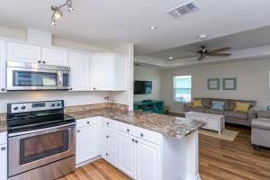 a kitchen with white cabinets and a living room at Rockport Getaway in Rockport
