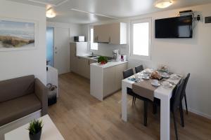 a kitchen and a dining room with a table and chairs at Floating House Marina Royal in Portorož