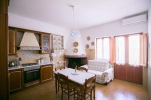 una cucina e un soggiorno con tavolo e divano di Casa Is Pascais - Explore South West Sardinia a Giba