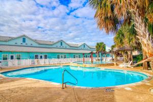 einem Pool mit Palmen vor einem Gebäude in der Unterkunft Nemo Cay 15106 in Corpus Christi