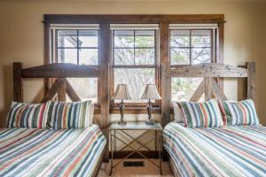 um quarto com 2 camas e uma janela em Rainbow Point Sabo Cabin em West Yellowstone