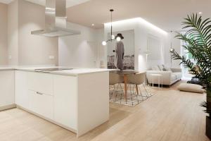 聖塞巴斯提安的住宿－Avenida Suite by FeelFree Rentals，一间带白色橱柜的厨房和一间客厅