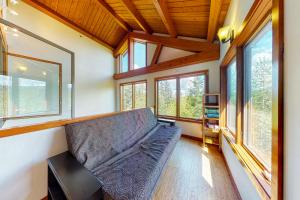 sala de estar con sofá y algunas ventanas en Woodland Hideaway in the Hills en Lake Stevens