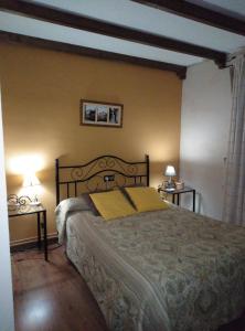 1 dormitorio con 1 cama grande y 2 mesas en Casa Rural El Arroyo en Sotoserrano
