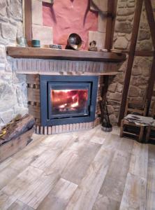 a fireplace in a room with a stone wall at Casa Rural El Arroyo in Sotoserrano