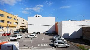 a parking lot with cars parked in front of a building at NARANJA in Arinaga +1 photo