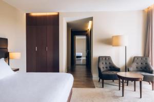a bedroom with a bed and two chairs and a table at Iberostar Selection Lagos Algarve in Lagos