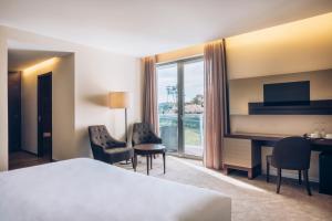 a hotel room with a bed and a desk and chairs at Iberostar Selection Lagos Algarve in Lagos