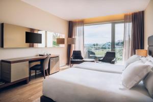 a hotel room with a bed and a desk with a computer at Iberostar Selection Lagos Algarve in Lagos