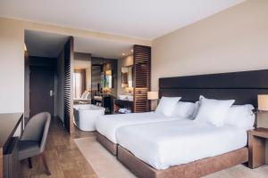 a bedroom with a large bed and a bathroom at Iberostar Selection Lagos Algarve in Lagos